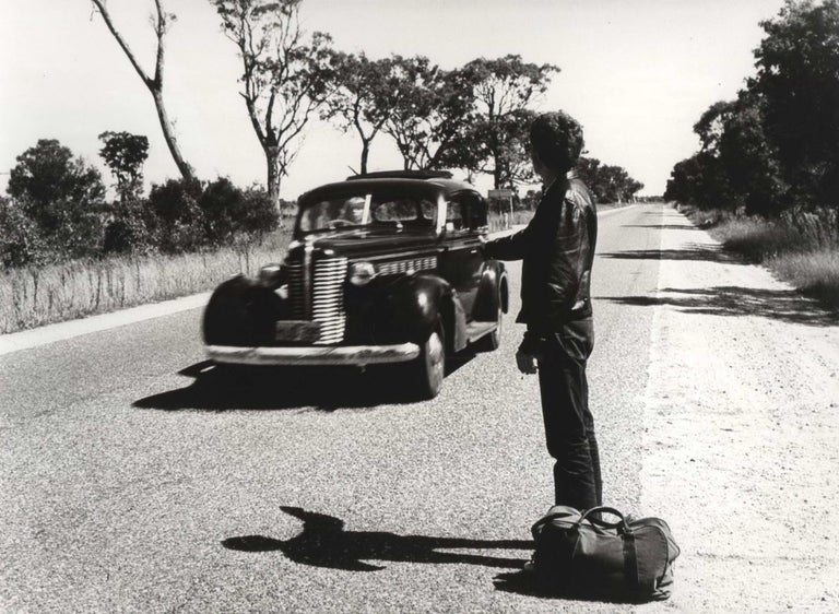 Item #CL186-25 [Richard Moir Hitchhiking While Judy Morris Drives On The Set Of “In Search Of Anna”]. Carol Jerrems, Aust.